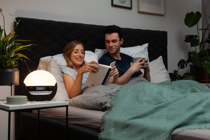 Two people taking time to reflect in bed with a Lumie Bodyclock 750DAB 